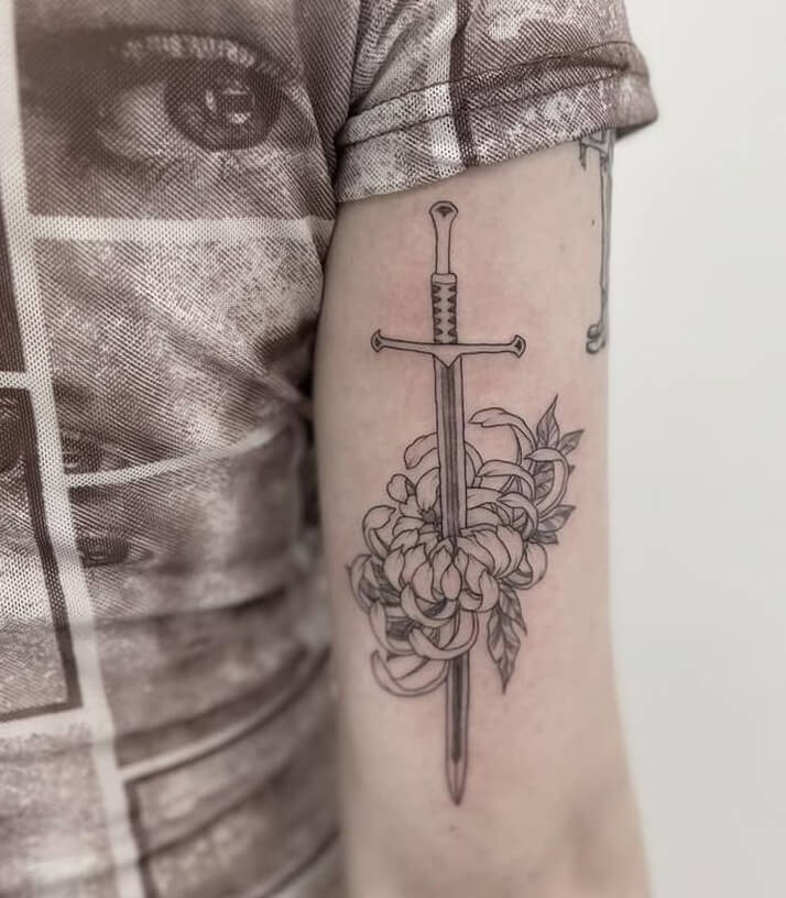 Sword Tattoo Design With a Single Flower On The Bicep